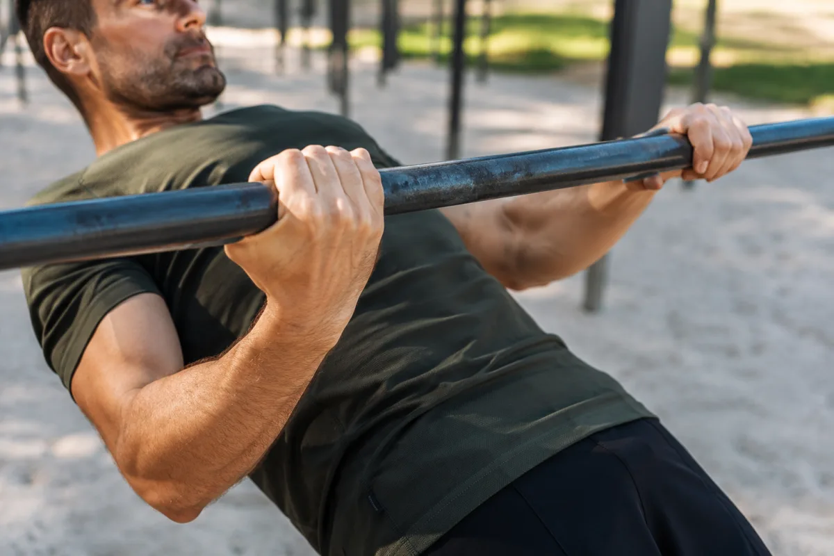 Gros plan sur les mains agrippant une barre lors d'un exercice de rowing inversé