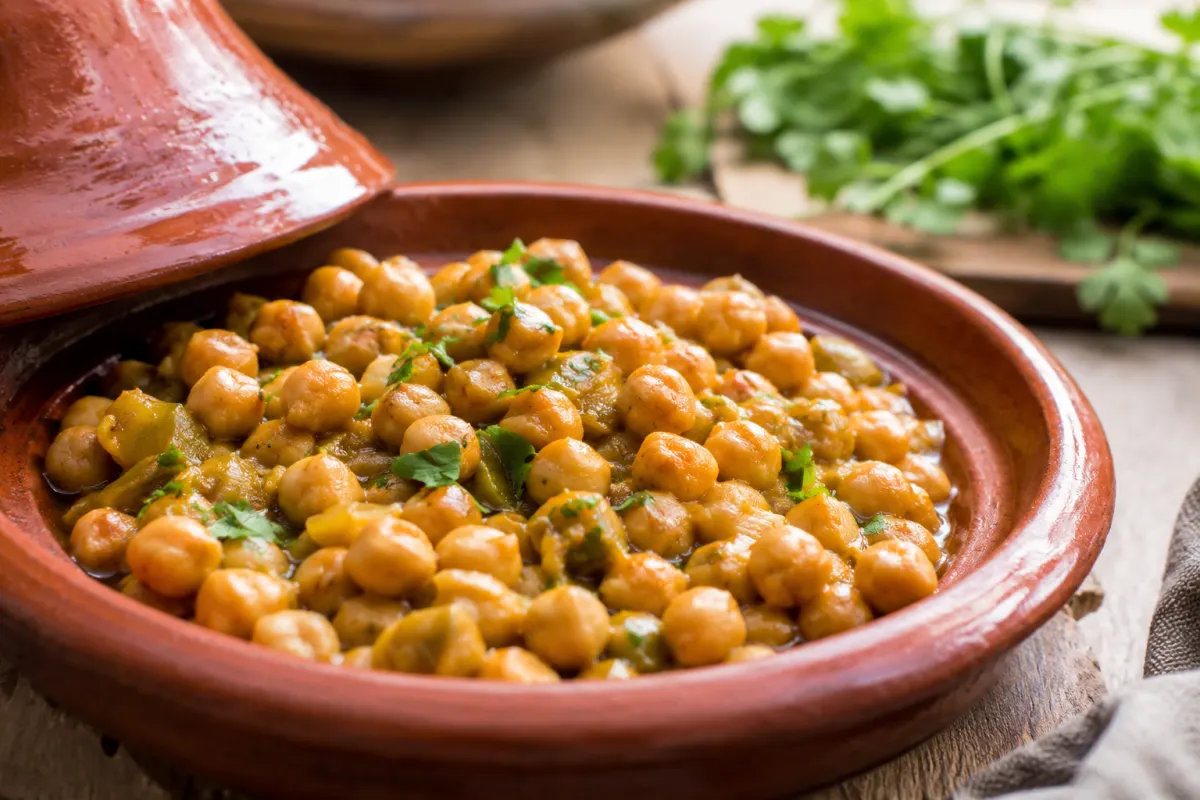 Gros plan sur des pois chiches épices et herbes fraîches dans une assiette en céramique